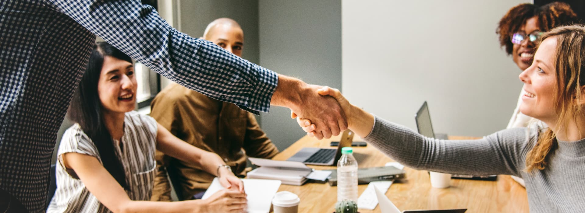 Estate agent shaking hands at a meeting.